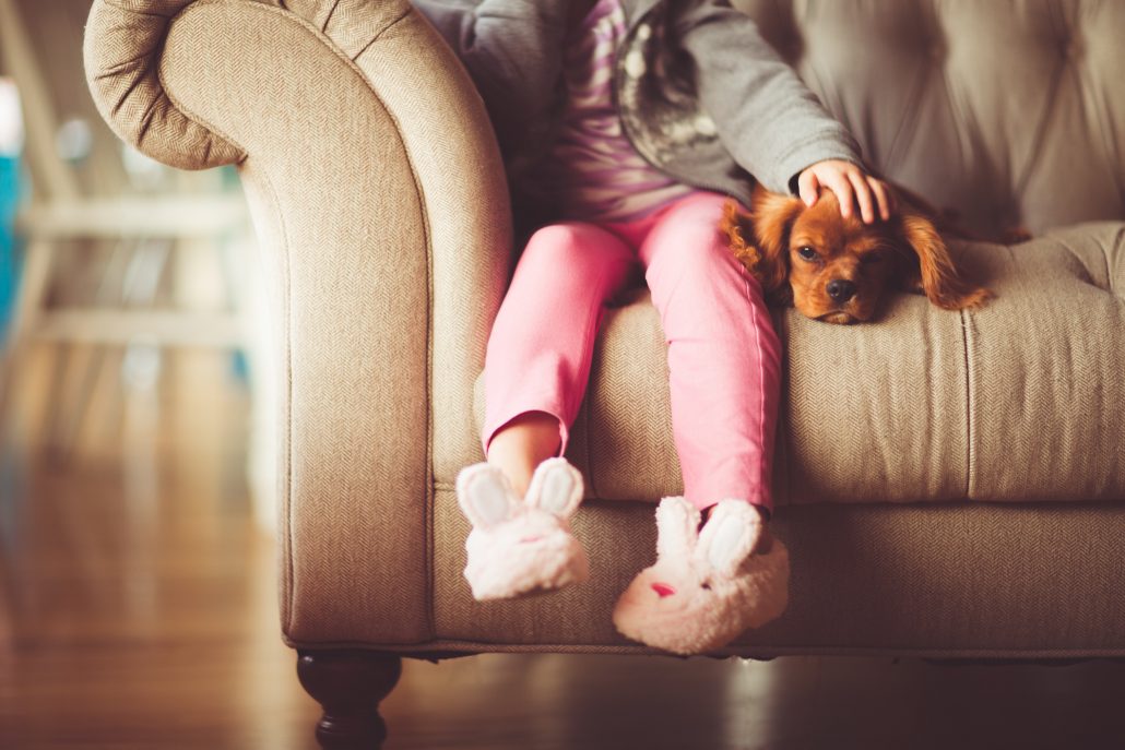 Little Girl on Couch with Puppy